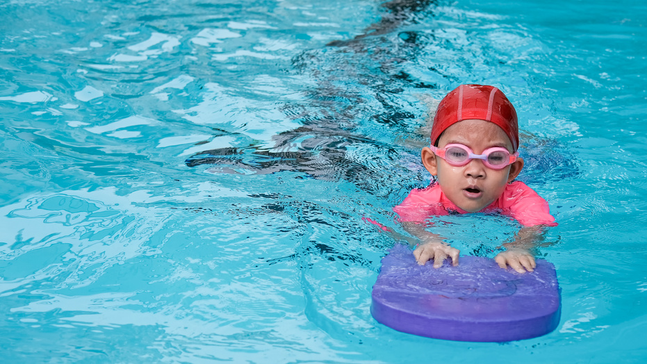 kid learn how to swim in swimming class
